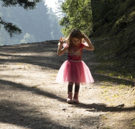 Ein Mädchen im Wald mit einem rosaraten Kleid, fotografiert von Jodi Bieber