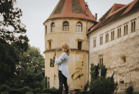 Saxophonspielerin vor einer Burg