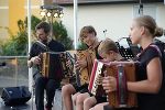 Schülerinnen und Schüler mit Musiklehrer bei Aufführung.